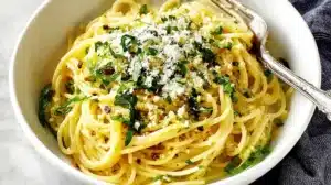 Creamy lemon garlic spaghetti topped with fresh parsley, Parmesan, and a sprinkle of red pepper flakes.