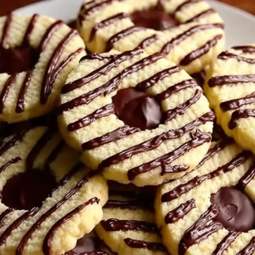 Fudge Stripe Cookies arranged on a plate, buttery rings with chocolate stripes and centers