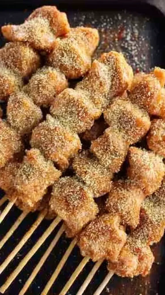 Golden Chicken Spiedini skewers stacked on a tray, coated in crispy garlic breadcrumb crust.