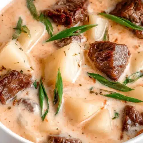 Creamy Steak and Potato Soup: Hearty & Amazing wide hero bowl with potato wedges, seared steak, and fresh herbs.