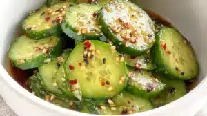 Japanese cucumber salad with sesame seeds, chili flakes, and soy-based dressing in a white bowl
