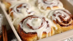 The BEST Cinnamon Roll Recipe: Soft, Gooey & Wonderful The BEST Cinnamon Roll Recipe with gooey cinnamon swirls and icing dripping over the edges in a baking dish