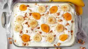 Easy banana pudding layered with vanilla wafers, sliced bananas, creamy pudding, and whipped topping in a glass dish