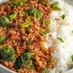 Firecracker Ground Chicken Bowl served with spicy ground chicken, broccoli, sesame seeds, green onions, and steamed white rice