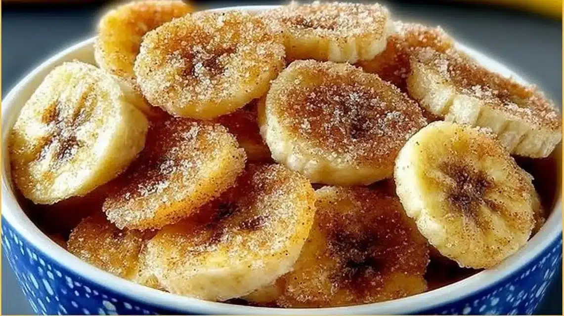 Cinnamon-sugar air fryer banana chips in a bowl, showcasing a crispy snack.