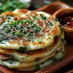 Crispy Chinese scallion pancakes served on a plate with dipping sauce.