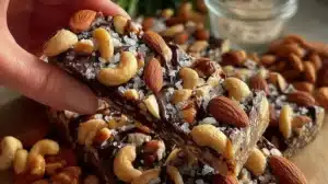 Dark chocolate and sea salt nut bars stacked on a wooden table