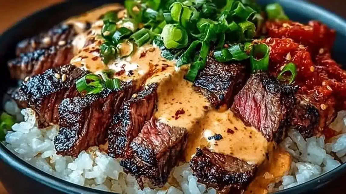 Korean BBQ Steak Rice Bowls (Better Than Takeout) 1 Korean BBQ steak rice bowl with spicy cream sauce garnished with vegetables