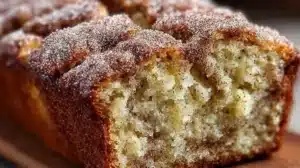 Snickerdoodle Banana Bread Recipe (Super Moist & Easy) Slice of freshly baked snickerdoodle banana bread on a wooden board