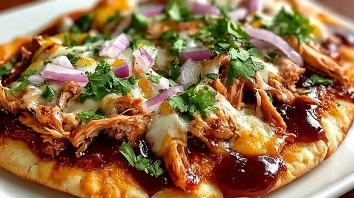 BBQ Chicken Flatbread for an Easy Cheesy Weeknight Dinner 1 BBQ chicken flatbread topped with fresh ingredients and drizzled with sauce.