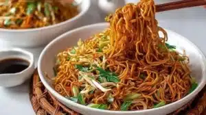Plate of Classic Chinese Fried Noodles served with vegetables and sauces