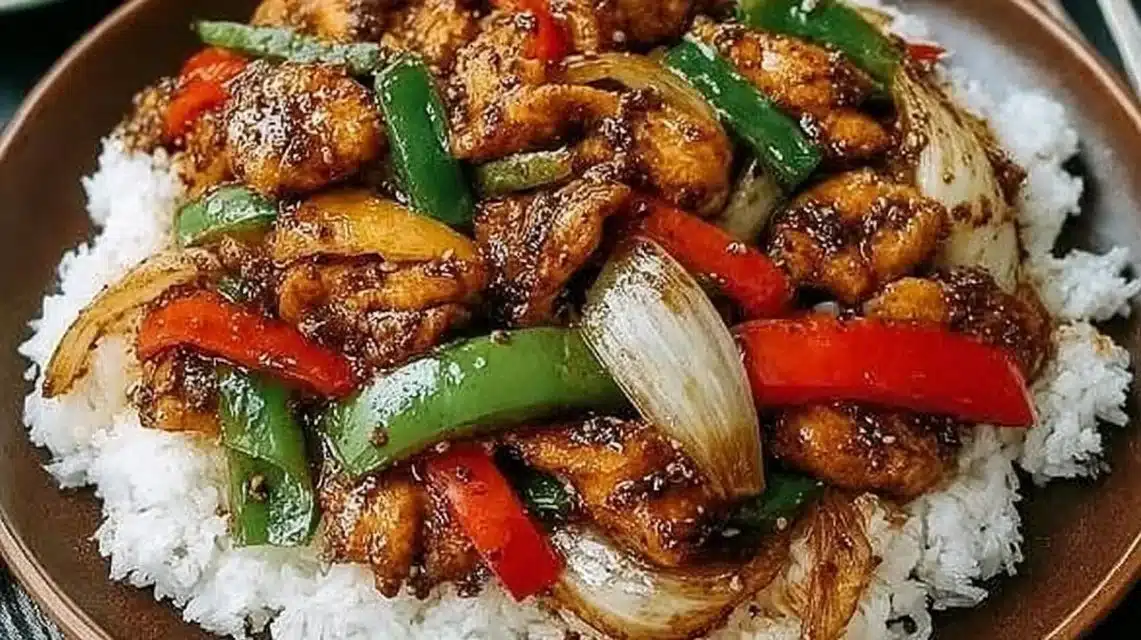 Delicious black pepper chicken dish garnished with fresh herbs.
