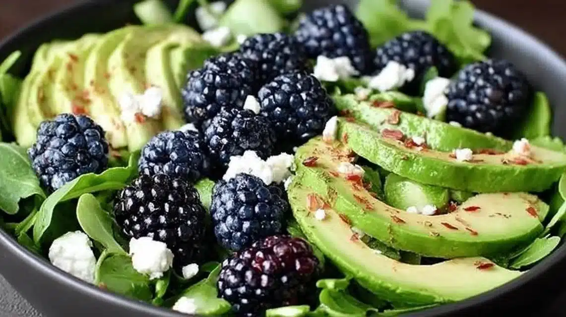 A vibrant blackberry avocado salad with greens and toppings for a healthy meal.