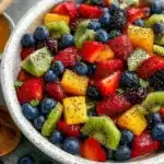 Fresh fruit salad with honey lime poppy seed dressing in a colorful bowl