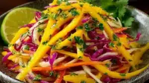 Colorful bowl of mango slaw with fresh vegetables and mango chunks