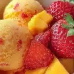 Delicious mango strawberry sorbet served in a bowl with fresh fruit