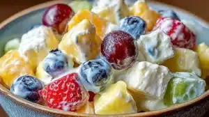 Delicious creamy fruit salad with colorful mixed fruits in a bowl