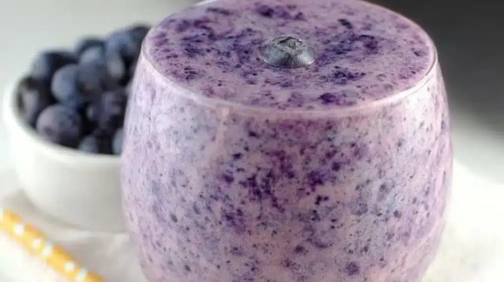 Blueberry Banana Protein Smoothie in a glass with fresh blueberries and banana slices
