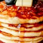 Fluffy buttermilk pancakes stacked with syrup and berries